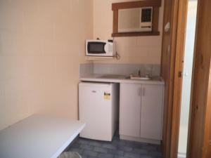 
a kitchen with a microwave, refrigerator, sink and dishwasher at Yarragon Motel in Yarragon
