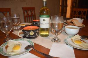een tafel met een fles wijn en borden eieren bij Laxapana Wilderness Home stay in Norton Bridge