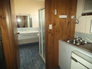 
a bathroom with a sink, toilet, and cabinets at Yarragon Motel in Yarragon
