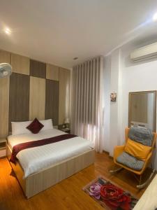 a hotel room with a bed and a chair at Phi Long Hotel in Tuy Hoa