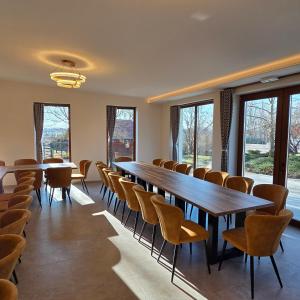 a conference room with tables and chairs and windows at Napvirág-Ház in Zsira