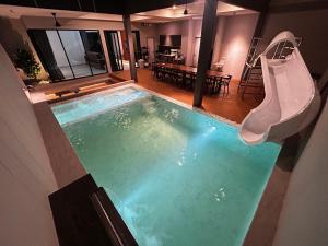 a swimming pool with a slide in a house at บลูด้าพูลวิลล่าซี Bludapoolvilla C in Ban Khlong Toei (1)