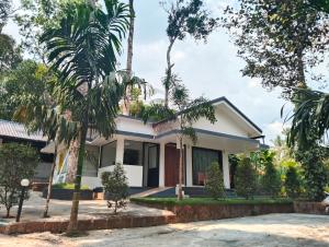 a house with palm trees in front of it at Green Leaf in Padinjarathara