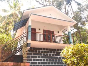 a house with a staircase leading up to it at Green Leaf in Padinjarathara +10 photos