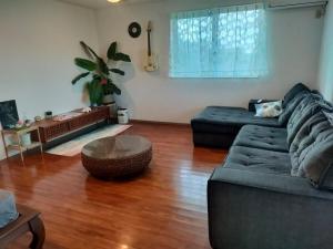 a living room with a couch and a table at ほぬのいえ Honu's house in Uruma