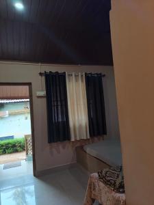 a room with black curtains and a table and a window at janaki Homestay in Gokarna