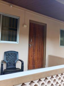a porch with a blue chair and a wooden door at janaki Homestay in Gokarna