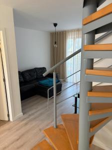 a living room with a staircase and a couch at Spacious duplex apartment in Overijse in Overijse