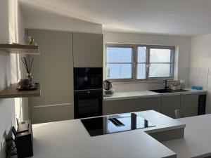 a white kitchen with a sink and a stove at Spacious duplex apartment in Overijse in Overijse