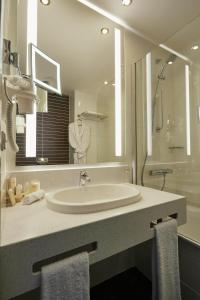 a bathroom with a sink and a large mirror at Tenet Hotel in Yekaterinburg