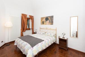 a bedroom with a bed and a mirror and a lamp at Casa Vacanza Le Piagge in Montelupo Fiorentino