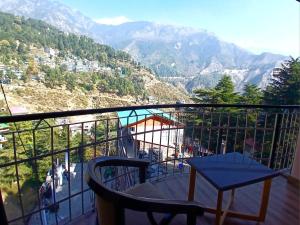 ein Balkon mit Tisch und Bergblick in der Unterkunft Hotel Cloud Hills in Dharamsala