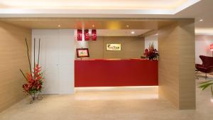 a lobby of a hotel with a red reception desk at Red Fox Hotel, Trichy in Tiruchchirāppalli