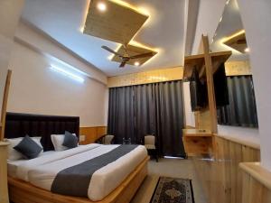 ein Schlafzimmer mit Bett und Deckenventilator in der Unterkunft Hotel Cloud Hills in Dharamsala + 11 Fotos