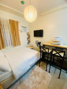 a bedroom with a bed and a desk with a computer at Casa Ona in Manila
