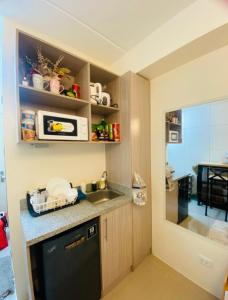 a small kitchen with a sink and a microwave at Casa Ona in Manila