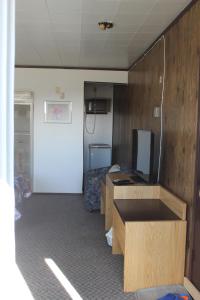 um quarto com duas secretárias e uma televisão num quarto em Raval Paradise Motel and RV Park em Youngstown