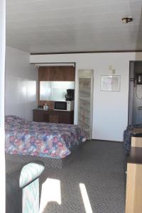 a hotel room with a bed and a kitchen at Raval Paradise Motel and RV Park in Youngstown