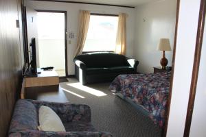 um quarto de hotel com uma cama e um sofá em Raval Paradise Motel and RV Park em Youngstown