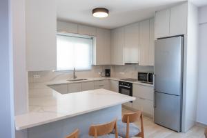 a kitchen with white cabinets and a refrigerator at Villa Palomar in Kyparissia