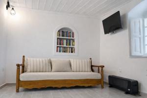 a couch in a living room with a book shelf at Lemon House in Hydra