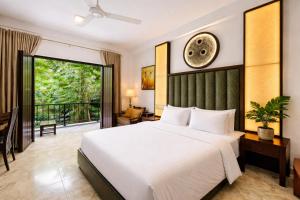 a bedroom with a large bed and a balcony at Sundaras Infinity Jungle Resort & Spa in Dambulla