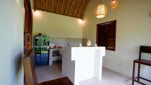 a kitchen with a counter in the middle of a room at D'Penglipuran Jungle House in Susut