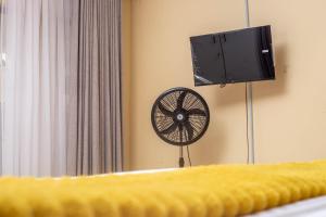 a bedroom with a fan and a tv on the wall at Pamusha Motel in Ngesi