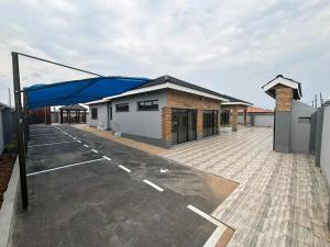 an empty parking lot with a blue covering on a building at Pamusha Motel in Ngesi