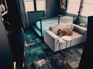 a living room with a couch and a chair at Green Rooms Braddon - Designer Micro Apartments in Braddon +10 photos