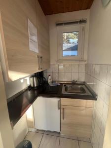a small kitchen with a sink and a window at Bungalow Beate in Zinnowitz +13 photos
