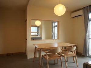 a dining room table with two chairs and a mirror at HITOYANE guesthouse-1日1組限定- in Aizuwakamatsu