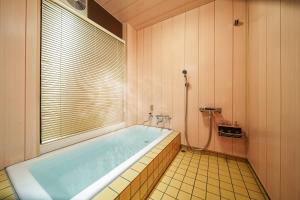 a bathroom with a large tub with a window at 夢思苑 別府 in Beppu +24 photos