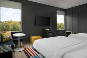 a hotel room with a bed and a tv at Aloft by Marriott Richmond West Short Pump in Short Pump +16 photos