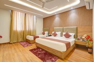 a hotel room with two beds and a window at Olive Aero Suites Plaza Inns Near Delhi International Airport in New Delhi