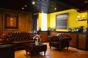 a living room with leather furniture and a bar at Suvarnabhumi Ville Airport Hotel in Lat Krabang