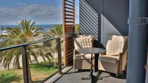 a balcony with two chairs and a table and the ocean at Beach paradise in Werribee South
