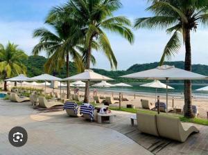 a group of chairs and umbrellas on a beach at Carola Pico De Loro in Nasugbu