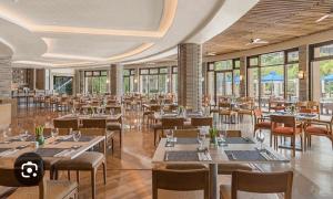 a restaurant with tables and chairs and windows at Carola Pico De Loro in Nasugbu