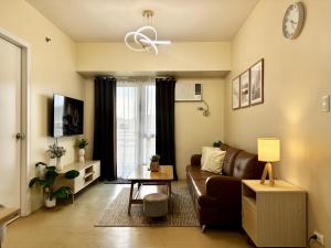 a living room with a couch and a window at 2-Bedroom Condo Unit with Balcony at Centrio Tower beside Ayala Centrio Mall Downtown CDO in Cagayan de Oro