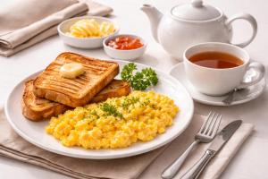 a plate of scrambled eggs and toast with a cup of tea at Bin-Umar Guest House chakswari in Burotiān