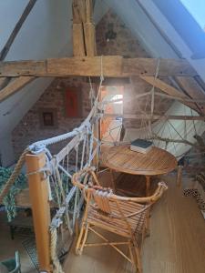 a table and a chair in a attic at Maison la Bambine chambre nature in Ozolles