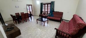 a living room with couches and a table and chairs at K Apartment in Varkala +4 photos