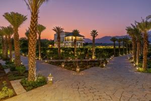 a resort with palm trees and a building at Merriment Luxury Resort & Private Pool Villa Near Mount Abu, Abu Road in Bhīmānia
