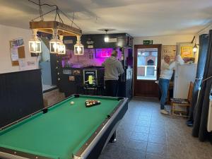 a pool table in a room with people standing around at Hillside Guesthouse Pushevo in Pushevo