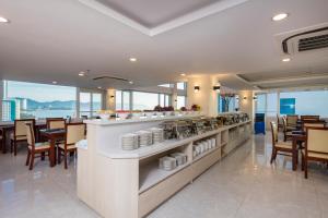 a restaurant with a buffet with chairs and tables at Sun City Hotel in Nha Trang