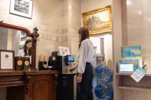 a woman standing at a counter in a coffee shop at New Osaka Hotel Shinsaibashi in Osaka