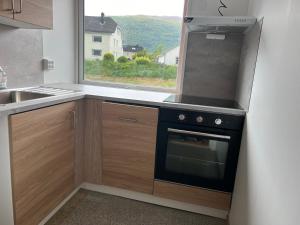 a kitchen with a stove and a sink and a window at Åndalsnes house in Åndalsnes