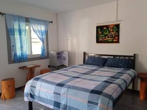 a bedroom with a bed with a blue and white blanket at Double P in Ban Phlong Sawai