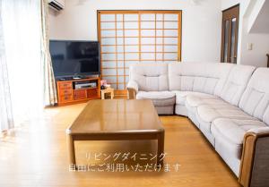 a living room with a couch and a coffee table at 民泊よこてこよ in Yokote
